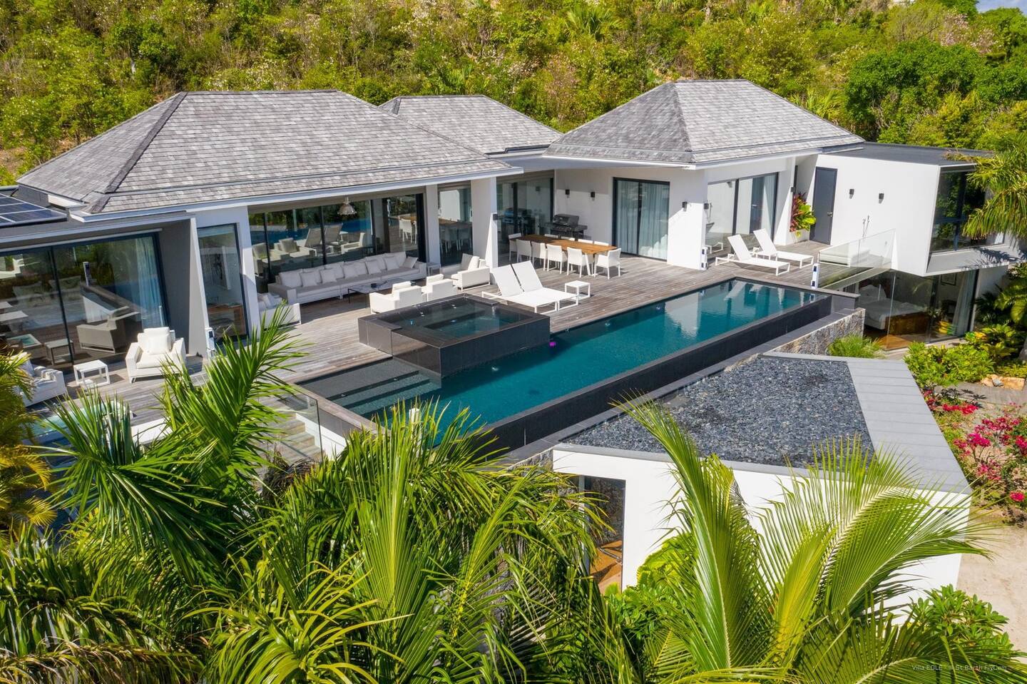 The patio has a heated infinity pool, a Jacuzzi, and plenty of lounge seats.
