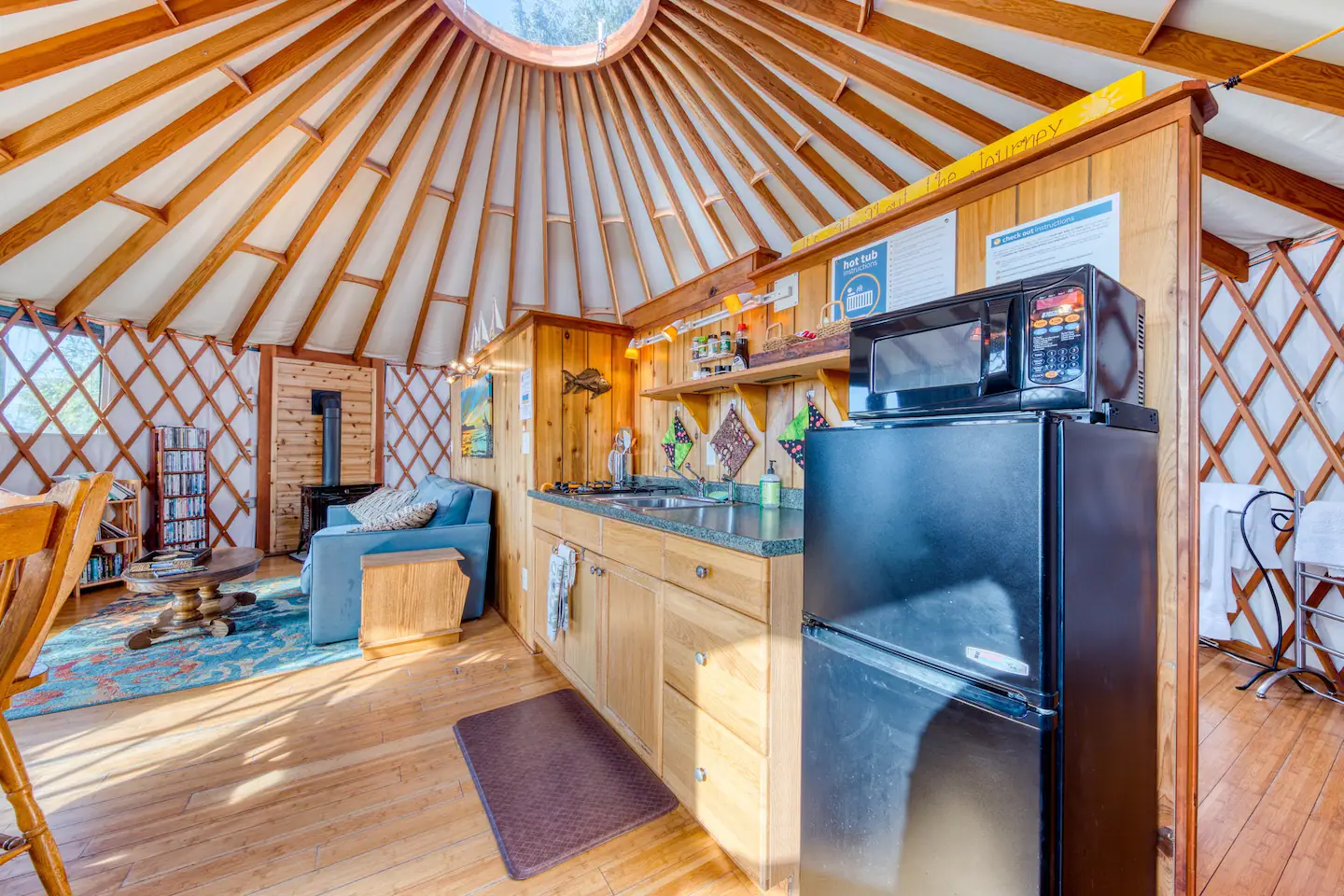 The kitchen is equipped with an oak pub table, beautiful dishes, and utensils, allowing you to produce home-cooked meals.