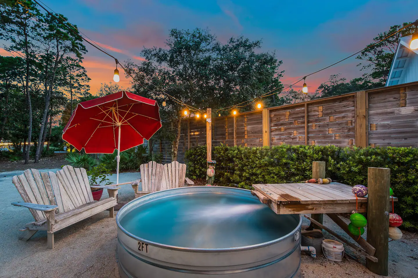 Outside, there is a lovely outdoor living area with string lights, a plunge pool, a BBQ grill, an outdoor shower, and a washer/dryer.