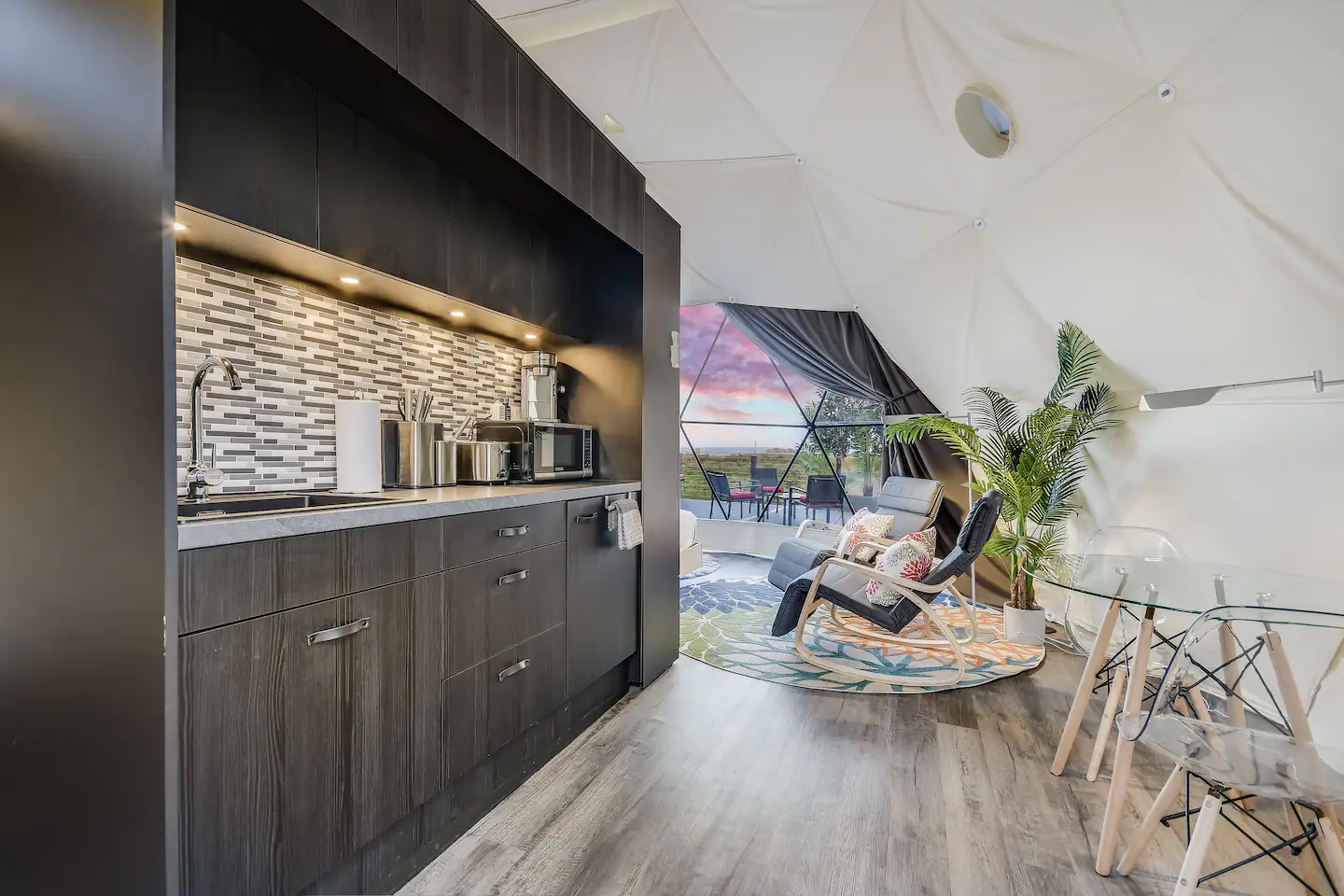 A toaster, coffee machine, microwave, mini-fridge, utensils, plates, and cooking bowls are provided in the kitchenette.