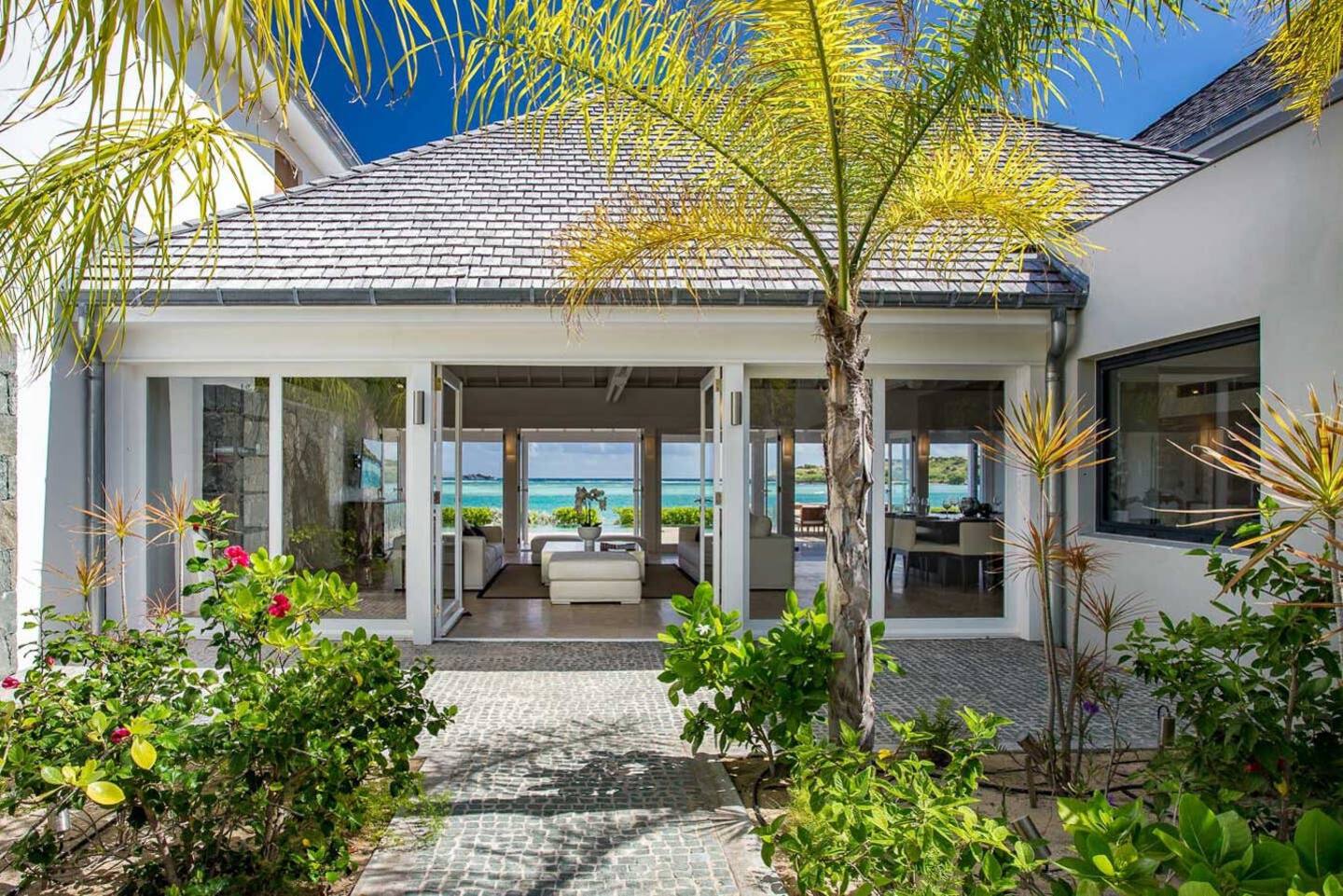 A lush and vibrant outdoor area surrounded by greenery, featuring manicured gardens, colorful flowers, and a variety of plants, creating a serene and natural environment.