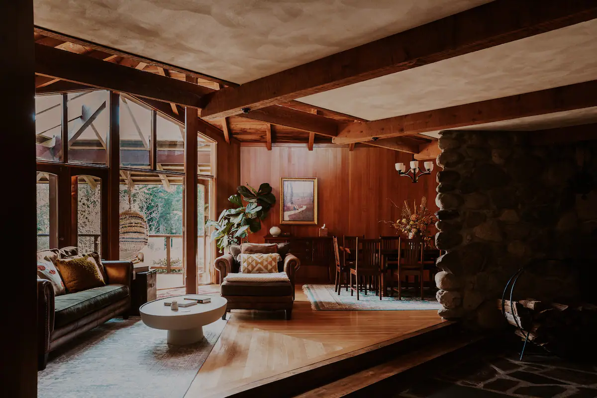 The Living Room seamlessly flows into the Dining Area, which features a sunken conversation area with a fireplace and an adjoining outdoor patio.
