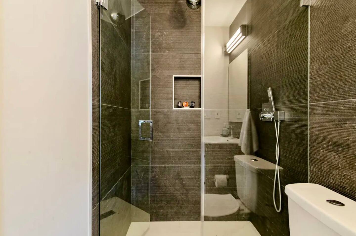 Guest full bath with textured Italian porcelain walls.