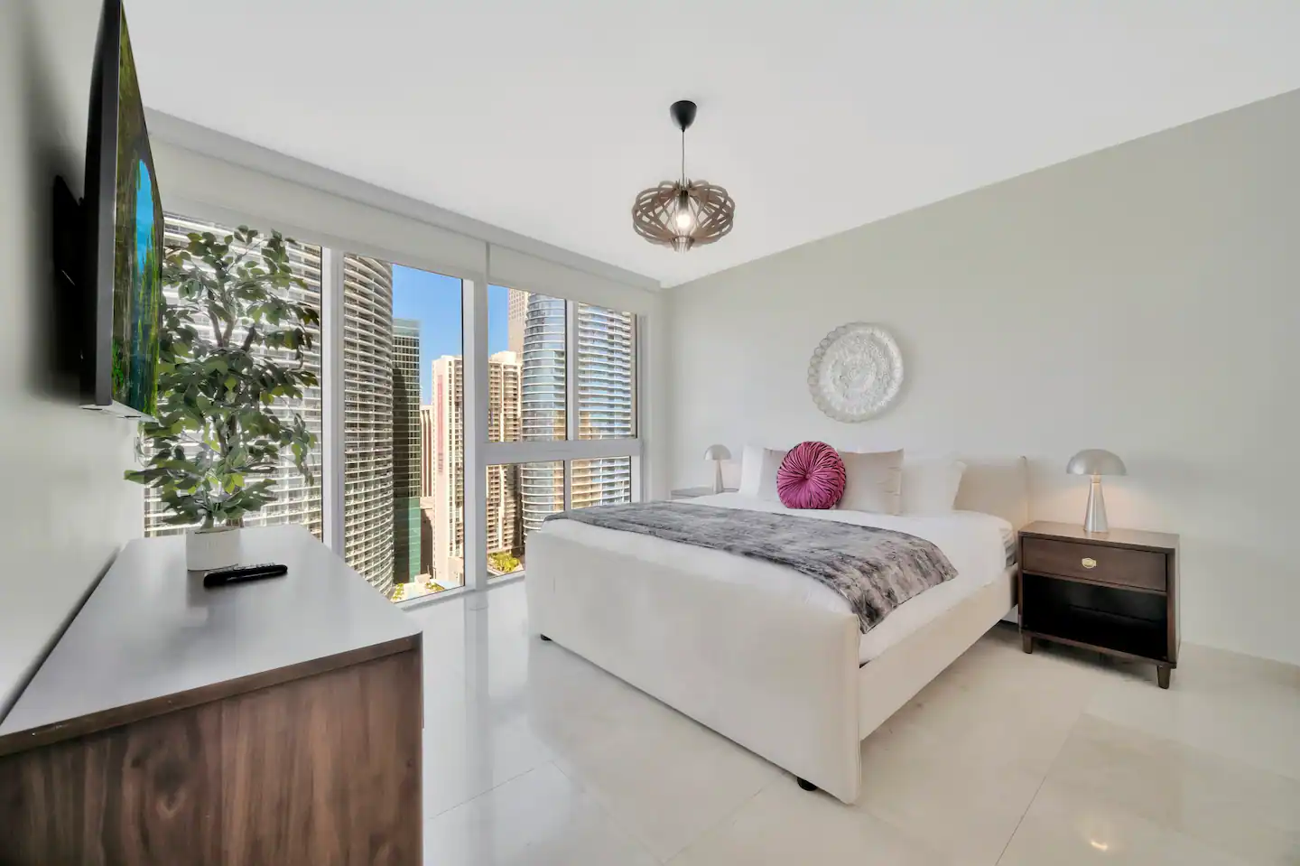 King bed with 60 inch smart tv in bedroom and view of ocean and river.