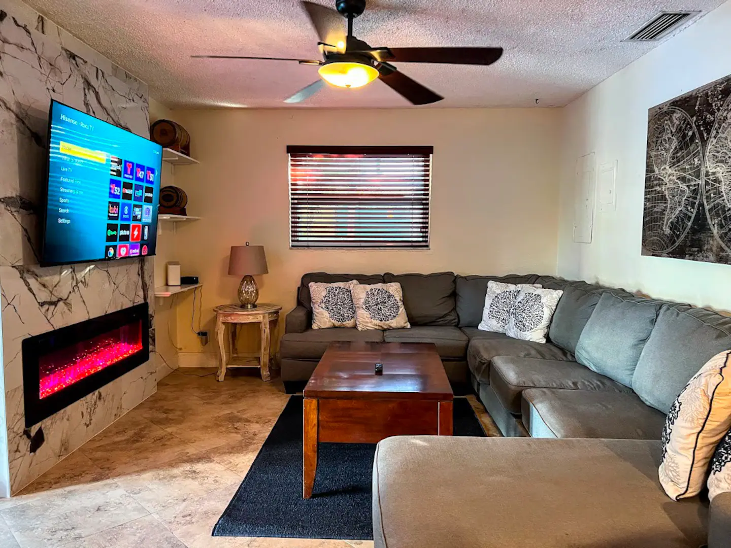 Open plan Living room with 65" TV, large wrap around sofa, cozy fireplace.