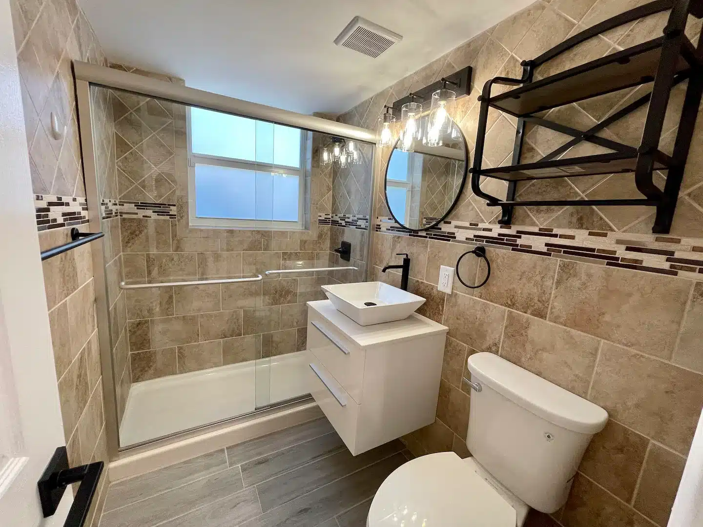 Newly renovated bathroom w/ new flooring, new floating solid-wood vanity, white quartz countertops & vessel sink, new elongated toilet, new shower and sink fixtures and new hurricane-impact, frosted glass window to ensure privacy.